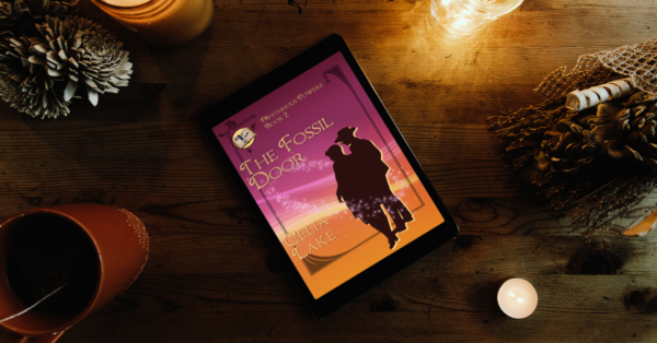 The Fossil Door cover displayed on an ereader, surrounded by candles, dried plants, and a mug of tea. The cover has a man and woman in silhouette at the right, looking to the left, on a background of dark burgundy to golden yellow, with an inset smaller image of an illuminated manuscript in the right corner.