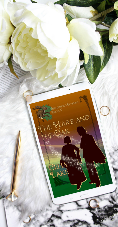 The cover of The Hare and The Oak displayed on a phone, surrounded by a white peony, small pieces of jewellery. The cover has a silhouetted man and woman talking to each other on a green and brown background, circled by stars, with a hare leaping out of an oakleaf inset in the top left corner.