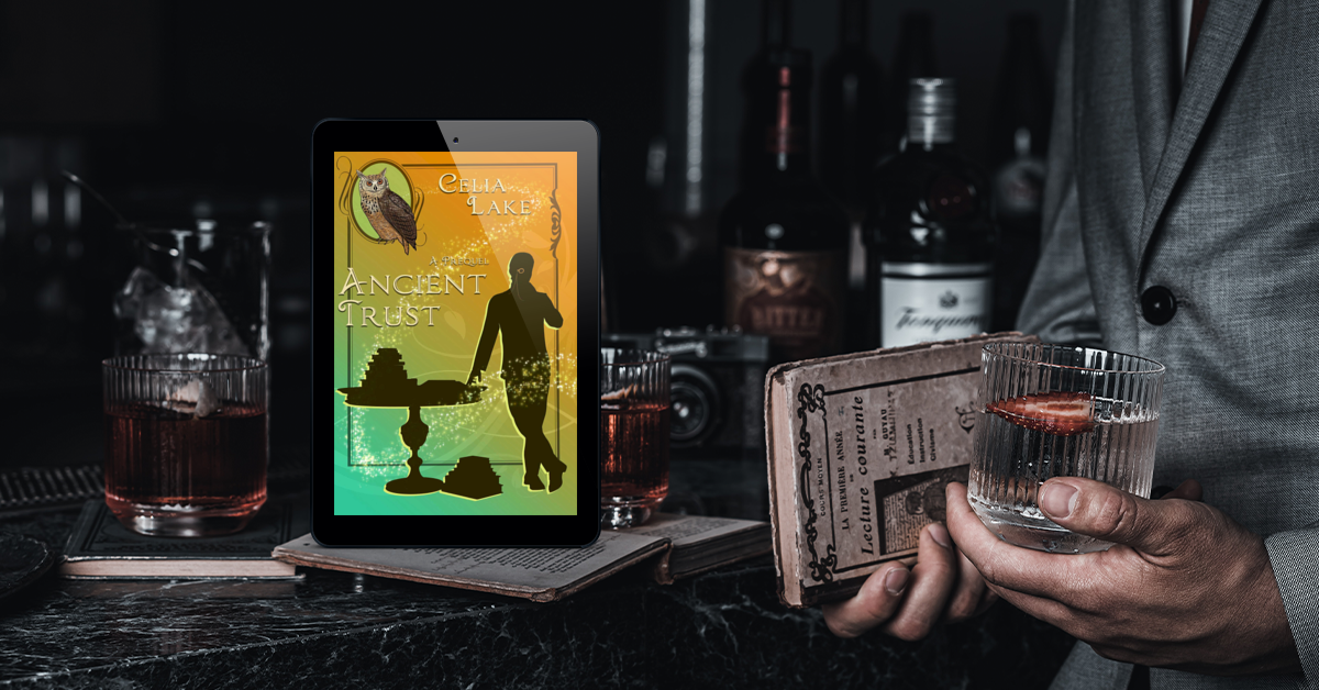 The cover of Ancient Trust on a tablet, surrounded glasses, bottles of alcohol, and a man in a tailored suit. The cover shows a man with a monocle in silhouette, leaning on a table stacked with books.