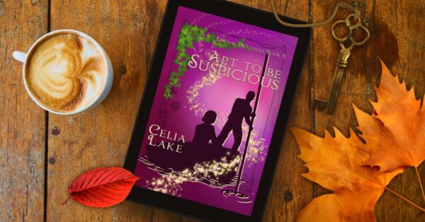 The cover of Apt to be Suspicious on a wooden table with a mug of coffee, a key, and two bright leaves, red and orange. The cover is a deep wine-purple, with a silhouetted man and woman. He is pushing a punt with a pole, and they are framed by ivy and a swirl of stars.